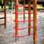 Maison de jeu en bois Activity Center avec structures d’escalade rouges dans une aire de jeux sablonneuse