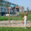 Des enfants grimpent et jouent sur un V-shape Net wooden playhouse dans un parc.