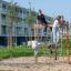 Des enfants jouent sur V-shape Net wooden playhouse dans un parc.