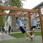 Des enfants jouent sur Horizontal Ladder wooden ladder dans une aire de jeux d'école.