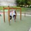 Des enfants jouent sur Horizontal Ladder wooden ladder dans une aire de jeux.