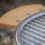 Grill avec une table d'appoint en bois et une grille métallique.
