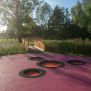 Round trampoline (150 cm) intégré dans un sol coloré, conçu pour aire de jeux moderne.