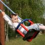 Jeune enfant en train de balancer sur la balançoire en bois Baby